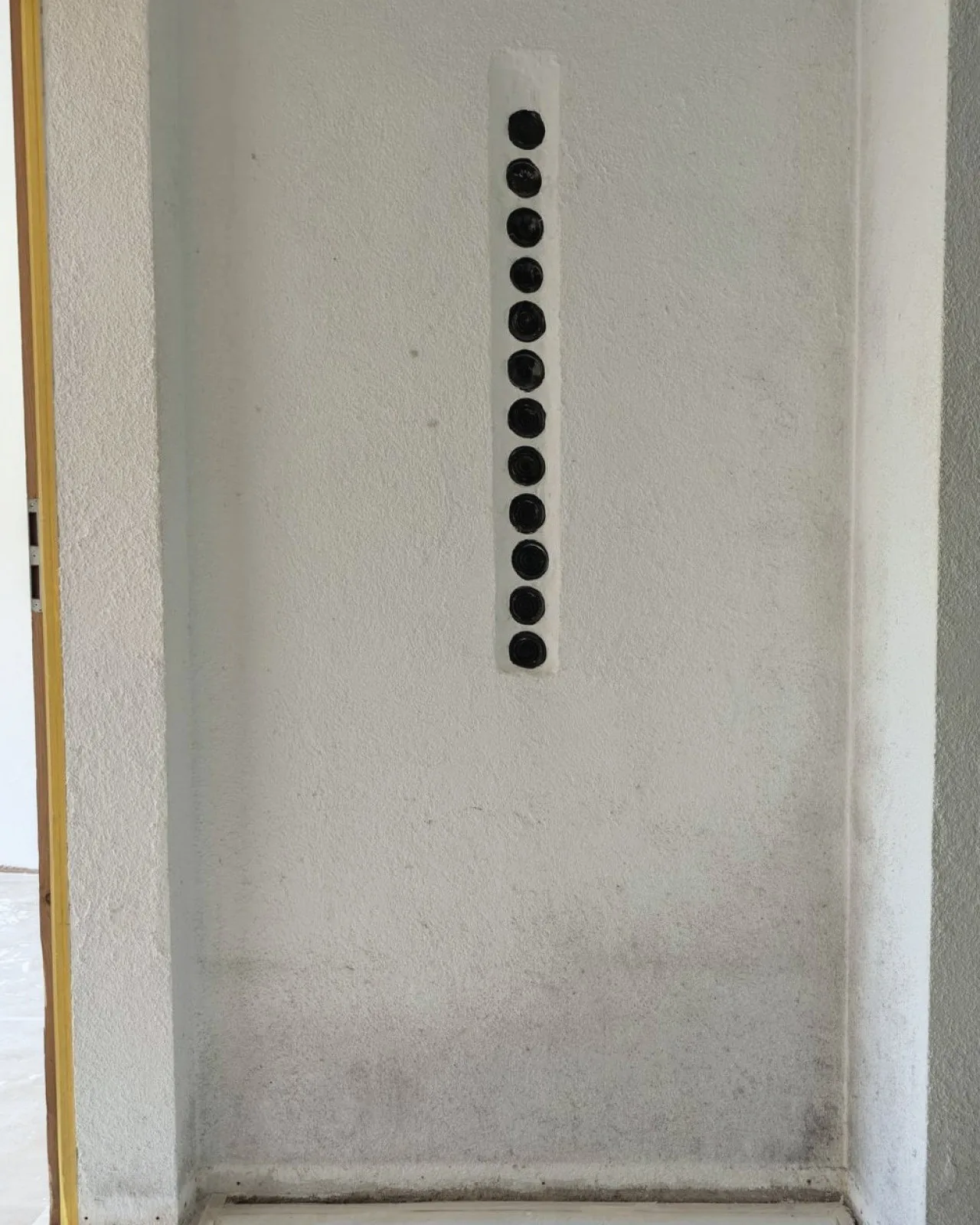 Mur au bas noirci par l’humidité et les salissures, avant assainissement