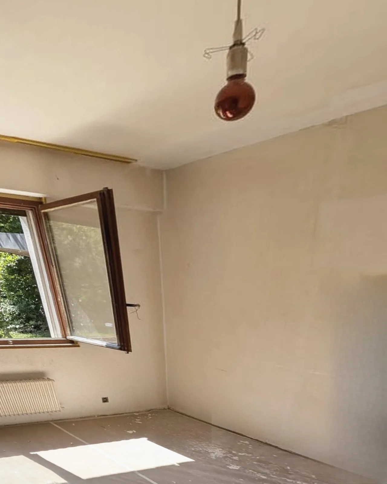 Chambre aux murs jaunis, fenêtre et radiateur, avant les travaux